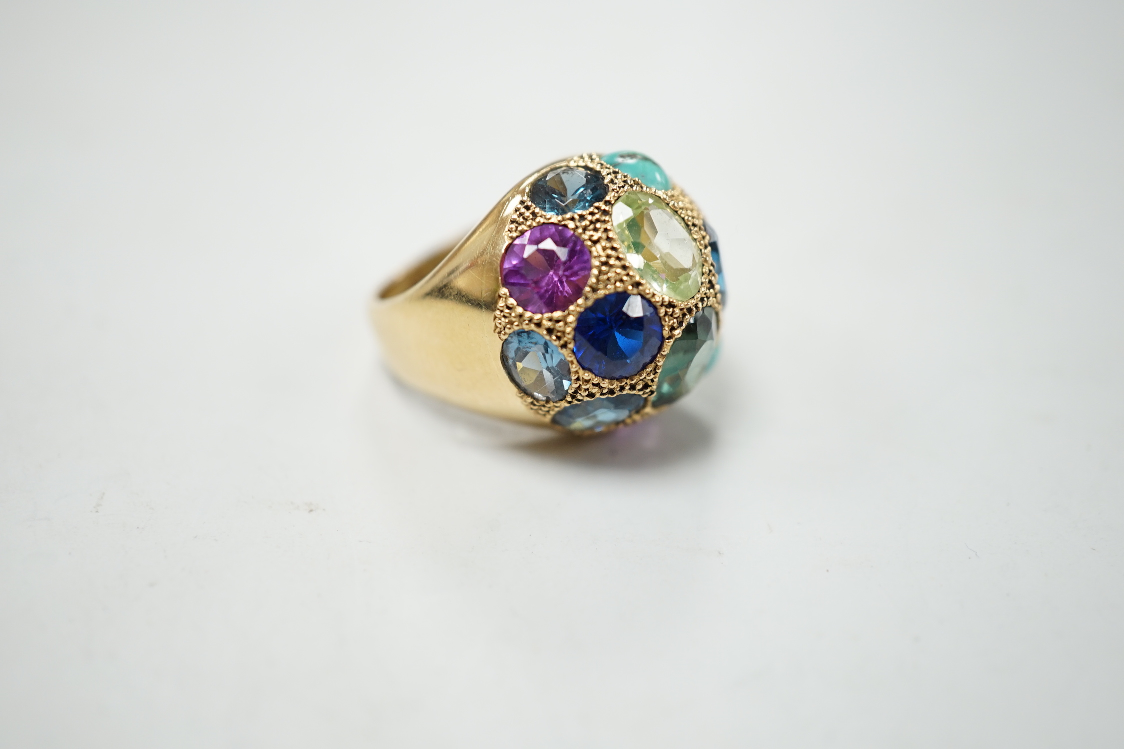 A Middle Eastern yellow metal and multi gem set domed dress ring, size K/L, gross weight 10.5 grams.